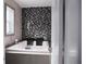 Bathroom with soaking tub, black and white accent tiles, and gray walls at 2600 Pisces Dr, Orlando, FL 32837
