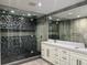 Modern bathroom featuring glass shower with black tile accent wall and double sink vanity with light countertop at 2600 Pisces Dr, Orlando, FL 32837