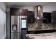Modern kitchen with stainless steel refrigerator, dark cabinets, and granite countertops at 2600 Pisces Dr, Orlando, FL 32837