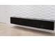 Modern storage unit featuring a glossy black finish, mounted on a textured white wall above tile flooring at 2600 Pisces Dr, Orlando, FL 32837