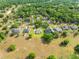 High aerial shot shows houses in a quiet neighborhood, set amidst abundant lush foliage, with golf course nearby at 26301 Sackamaxon Dr, Sorrento, FL 32776