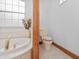 Well-lit bathroom featuring a soaking tub, toilet, and a window at 26301 Sackamaxon Dr, Sorrento, FL 32776