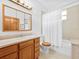 Standard bathroom with a single sink vanity, neutral tile, bathtub, and toilet at 26301 Sackamaxon Dr, Sorrento, FL 32776