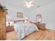 Bright bedroom featuring hardwood floors, white walls, ceiling fan, and coordinated wicker furniture set at 26301 Sackamaxon Dr, Sorrento, FL 32776