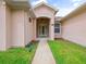 Inviting home entrance with a covered porch, stylish door, and green grass at 26301 Sackamaxon Dr, Sorrento, FL 32776