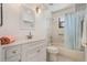 Clean bathroom with a vanity, toilet, and shower with blue curtains at 26535 Deuce Ct, Leesburg, FL 34748