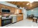 Bright kitchen with stainless steel appliances, wood cabinets and a unique wood plank ceiling at 26535 Deuce Ct, Leesburg, FL 34748