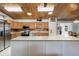 Bright kitchen featuring an island, stainless steel appliances, wood plank ceiling, and natural wood cabinets at 26535 Deuce Ct, Leesburg, FL 34748