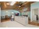 Bright kitchen featuring an island, stainless steel appliances, wood plank ceiling, dining table, and living room at 26535 Deuce Ct, Leesburg, FL 34748