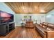 Comfortable living room featuring hardwood floors, a leather sofa, and a mounted TV at 26535 Deuce Ct, Leesburg, FL 34748