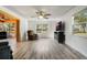 Bright living room with hard surface flooring, large windows, and a ceiling fan at 26535 Deuce Ct, Leesburg, FL 34748