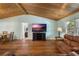 Living room and dining room featuring hardwood floors, a leather sofa, and a mounted TV at 26535 Deuce Ct, Leesburg, FL 34748