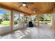 Inviting sunroom filled with light, wood ceiling, ceiling fans, and views of the backyard at 26535 Deuce Ct, Leesburg, FL 34748