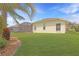 Lush backyard with vibrant lawn, mature trees and the corner of a screened in lanai at 27024 Old English Ct, Leesburg, FL 34748
