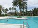 A large community pool features ample lounge seating and mature tropical landscaping at 27024 Old English Ct, Leesburg, FL 34748