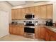 This modern kitchen has stainless steel appliances, light wood cabinetry, and granite countertops at 27024 Old English Ct, Leesburg, FL 34748