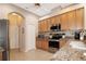 Well-lit kitchen features stainless steel appliances, granite counters, and wood cabinets at 27024 Old English Ct, Leesburg, FL 34748