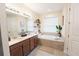 Bright bathroom features a soaking tub, double vanity, and plants, creating a spa-like atmosphere at 2749 Hilltop Rd, Clermont, FL 34711