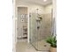 Glass enclosed shower features stone tile surround, and convenient built-in shelving, a perfect spot to unwind at 2749 Hilltop Rd, Clermont, FL 34711