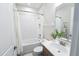 All-white bathroom featuring a shower-tub combo and single vanity offers a clean and functional space at 2749 Hilltop Rd, Clermont, FL 34711