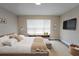 Sunlit bedroom features a window bench, accent rug and a wall-mounted TV, combining style and functionality at 2749 Hilltop Rd, Clermont, FL 34711