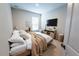 Cozy bedroom features a large window, mounted TV, accent chair, and neutral decor, offering a relaxing retreat at 2749 Hilltop Rd, Clermont, FL 34711
