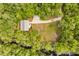 Overhead aerial view of a secluded property featuring a home and oversized detached garage surrounded by trees and a river at 2870 Belinda Dr, Deland, FL 32720