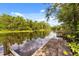 Wooden dock view on a serene river, reflecting sky and trees, offering peaceful waterfront access at 2870 Belinda Dr, Deland, FL 32720
