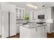 Bright updated kitchen featuring white cabinets, modern appliances, and a marble countertop island at 2870 Belinda Dr, Deland, FL 32720