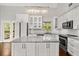 Bright, updated kitchen featuring white cabinets, modern appliances, and a marble countertop island at 2870 Belinda Dr, Deland, FL 32720