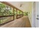 Large screened porch with wood flooring, ceiling fans, and views of lush greenery at 2870 Belinda Dr, Deland, FL 32720