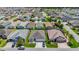 An aerial view of a neighborhood featuring well-maintained homes and manicured lawns on a sunny day at 2992 Hicks Pl, The Villages, FL 32163