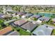 This aerial view shows multiple homes with lush landscaping, serene ponds, and well-maintained roofs at 2992 Hicks Pl, The Villages, FL 32163