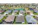An aerial view of the community shows lush green lawns, various roofs, and a community pond at 2992 Hicks Pl, The Villages, FL 32163