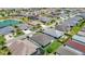 Aerial view of the neighborhood showcases the many homes, community pond, and manicured landscaping at 2992 Hicks Pl, The Villages, FL 32163