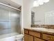 Bathroom featuring granite countertops, wood cabinets, toilet, and a glass door shower at 2992 Hicks Pl, The Villages, FL 32163