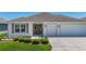 Exterior shot showing landscaping, driveway, and a two-car garage at 2992 Hicks Pl, The Villages, FL 32163