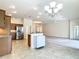 Open floor plan with stainless steel appliances, light countertops, and an island in the kitchen at 2992 Hicks Pl, The Villages, FL 32163