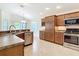 Well-lit kitchen featuring stainless steel appliances, granite countertops, and a view of the dining area at 2992 Hicks Pl, The Villages, FL 32163