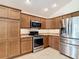 Modern kitchen featuring stainless steel appliances, ample cabinet space, and tile flooring at 2992 Hicks Pl, The Villages, FL 32163