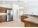 Open kitchen with stainless steel refrigerator, granite countertops, and a view of the dining area at 2992 Hicks Pl, The Villages, FL 32163