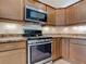 Close-up of a modern kitchen with stainless steel appliances, granite countertops, and ample cabinet space at 2992 Hicks Pl, The Villages, FL 32163