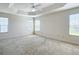 Spacious main bedroom featuring neutral walls, carpet flooring, a ceiling fan, and tray ceiling at 2992 Hicks Pl, The Villages, FL 32163