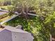 Aerial view of backyard surrounded by a white fence and mature trees, providing privacy and space at 301 Brookstone Ln, Fruitland Park, FL 34731