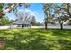 Expansive backyard enclosed by a white fence and adorned with mature shade trees at 301 Brookstone Ln, Fruitland Park, FL 34731