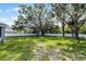 Lush backyard featuring a well-maintained lawn, mature trees, and a white fence at 301 Brookstone Ln, Fruitland Park, FL 34731