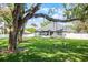 Spacious backyard with mature trees, lawn, and a playful tree swing set at 301 Brookstone Ln, Fruitland Park, FL 34731