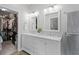 Bathroom features double sinks, marble countertops and a walk-in closet in the background at 301 Brookstone Ln, Fruitland Park, FL 34731