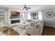 Cozy living room with fireplace, large sectional couch, and modern ceiling fan at 301 Brookstone Ln, Fruitland Park, FL 34731