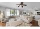 Spacious living room features large sectional sofa, ceiling fan, and view into the kitchen at 301 Brookstone Ln, Fruitland Park, FL 34731